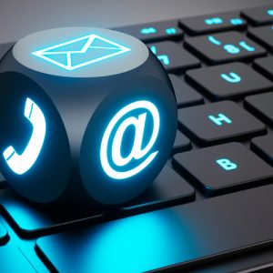 lighted computer keyboard with a lighted die showing email and phone icons
