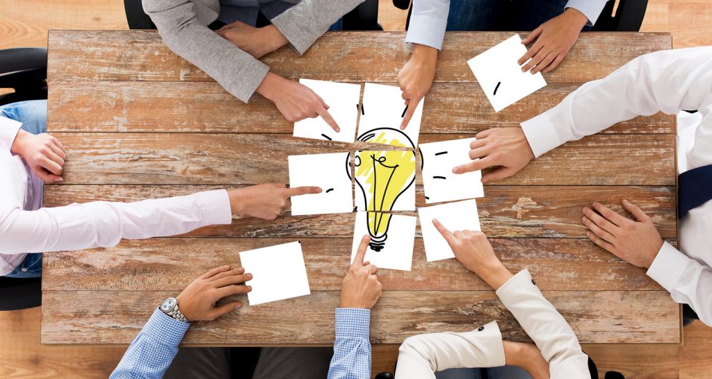 close up of business team with light bulb puzzle